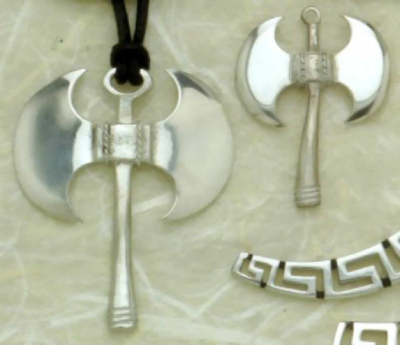Silver pendants with the double-headed labrys motif